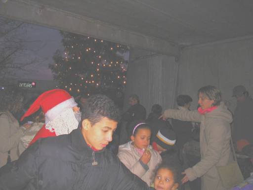 Babbo Natale tra i bambini sullo sfondo l'albero di Natale